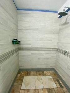 un bagno con ampia doccia e piastrelle bianche di Zen Cove w/rental vehicle access a Gros Islet
