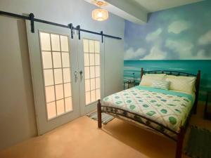 a bedroom with a bed and a painting of the ocean at Zen Cove w/rental vehicle access in Gros Islet