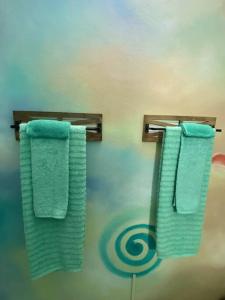 Duas toalhas verdes penduradas num toalheiro na casa de banho em Zen Cove w/rental vehicle access em Gros Islet