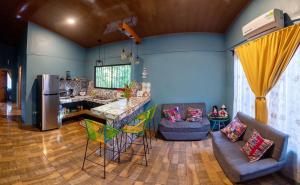 a kitchen and living room with a refrigerator and a table at Casa Encanto in Puntarenas