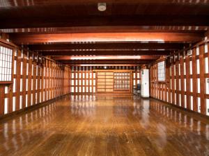 una stanza vuota con pavimento e finestre in legno di Misato Town Community Lodge Wakuasu a Daisen