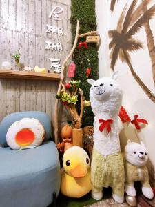 un grupo de animales de peluche sentados junto a una silla en 棚棚屋室內帳篷民宿Inn, en Kaohsiung