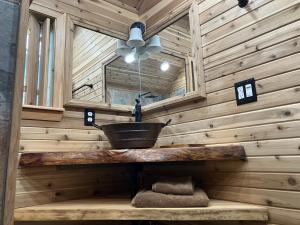 Cabaña de madera con lavabo y ventilador de techo en Two Lakes Guesthouse, en Seward