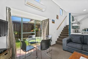 a living room with a glass table and chairs at Queenstown Gateway Apartments in Queenstown