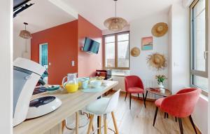 cocina con paredes de color naranja y blanco, mesa y sillas en 1 Bedroom Stunning Apartment In Melrand, en Melrand
