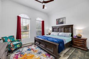 um quarto com uma cama, uma cadeira e janelas em Frisco Resort Style Home w/Spa em Frisco