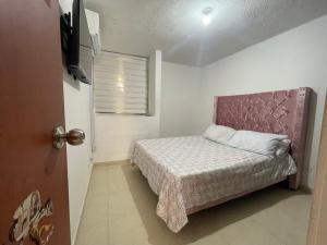 een kleine slaapkamer met een bed en een raam bij Cómodo paramento zona norte in Barranquilla