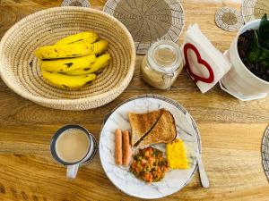 una mesa con un plato de comida con plátanos y tostadas en Venem house, en Arusha 22 fotos más
