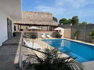 un resort con piscina e tetto di paglia di Cabaña Cerca Santa Verónica a Juan de Acosta
