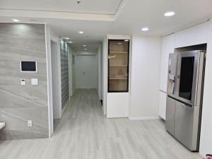um quarto vazio com um corredor com um frigorífico em Haeundae Chocho house stay 1 em Busan