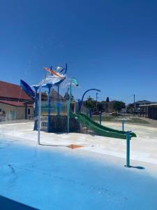 a playground with a slide in a park at Modern Retro Retreat in Tuncurry