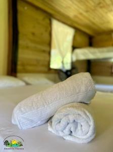 a rolled up towel sitting on top of a bed at ECO-Hotel Amanecer Tayrona dentro del parque tayrona in El Zaino