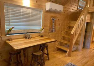 a log cabin kitchen with a sink and stairs at Serene 1BR Cabin near NC Z00 with Loft & Waterview in Asheboro