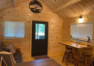 a log cabin with a table and a black door at Serene 1BR Cabin near NC Z00 with Loft & Waterview in Asheboro +10 photos