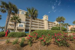 a large building with palm trees and pink flowers at Holiday Inn Club Vacations Panama City Beach Resort in Panama City Beach
