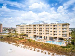 a hotel with a swimming pool next to a body of water at Holiday Inn Club Vacations Panama City Beach Resort in Panama City Beach