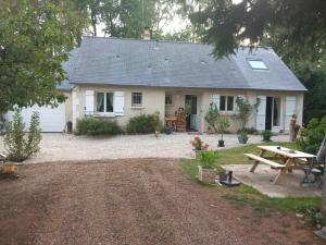 uma casa branca com uma mesa de piquenique e um banco de piquenique em Le Sapin Parasol - Maison pour 7 pers. em Lussault-sur-Loire