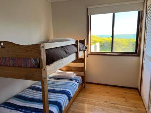1 Schlafzimmer mit 2 Etagenbetten und einem Fenster in der Unterkunft C4 Miles Beach Shack in Robe