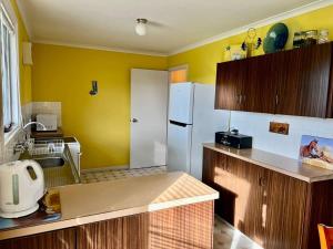 a kitchen with yellow walls and a white refrigerator at Robey - Robe in Robe