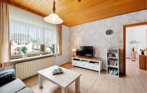 ein Wohnzimmer mit einem Sofa, einem TV und einem Tisch in der Unterkunft 4 Bedroom Nice Home In Oberelz 