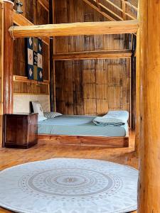 a bed in a wooden room with a rug at Homestay số 91-Suối Hồ Sa Pa in Sapa