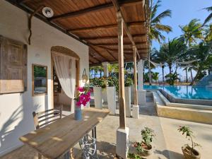 a patio with a wooden table and a pool at Deep Blue in Matara