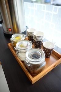a tray with several jars and cups on a counter at Front One Budget Malang by Azana in Malang