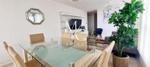uma sala de jantar com uma mesa de vidro e cadeiras em MC SUITE NORTE - 100 MT² - 3 HABITACIONES em Antofagasta