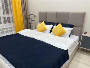 1 dormitorio con 1 cama con almohadas amarillas en Рио en Kirovo