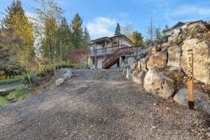 a house on a hill with a gravel driveway at Vi Cottage in North Saanich