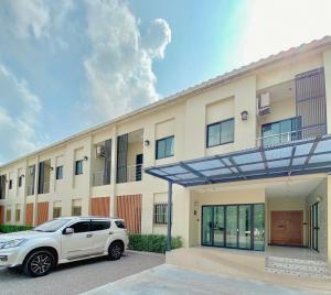 春蓬Calamint Residence Hotel ( คาลามิ้นท์)的一辆白色汽车停在一栋建筑物前