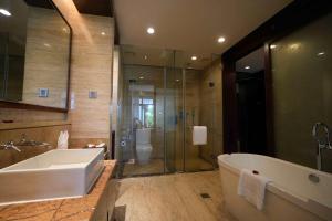łazienka z wanną, prysznicem i toaletą w obiekcie Grand Metropark Villa Resort Sanya Yalong Bay w mieście Sanya