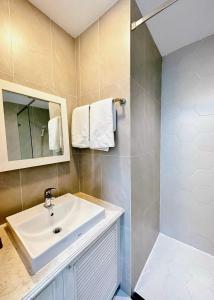 a bathroom with a sink and a mirror and a shower at Thinh Vuong Apartment IX in Ho Chi Minh City