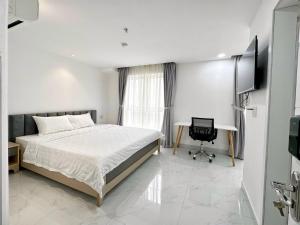 - une chambre avec un lit, un bureau et une télévision dans l'établissement Thinh Vuong Apartment IX, à Hô-Chi-Minh-Ville