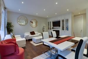 een woonkamer met een witte tafel en stoelen bij Luxury house In Scarborough in Toronto