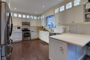 a kitchen with white cabinets and a refrigerator at Luxury house In Scarborough in Toronto