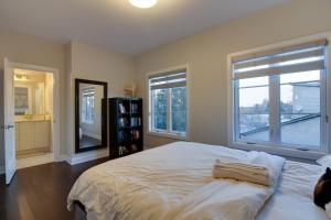 een slaapkamer met een groot bed en 2 ramen bij Luxury house In Scarborough in Toronto