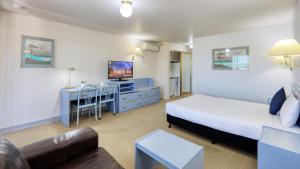 sypialnia z łóżkiem, telewizorem i kanapą w obiekcie Sunrise Devonport w mieście Devonport