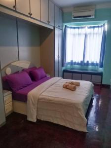 a bedroom with a large bed with purple pillows at Pd Bayu Beach Resort Apartment A2.16 in Port Dickson