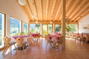 a dining room with tables and chairs and windows at Ferienwohnung Cuntera in Curaglia