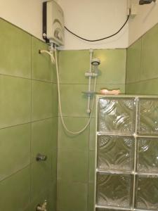 y baño verde con ducha y cabezal de ducha. en Lady Gordons Homestay, en Kandy