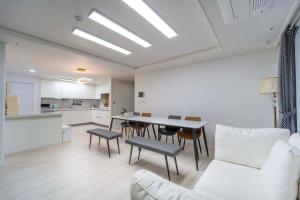 a living room and kitchen with a table and chairs at Haeundae Chocho stay 2 in Busan