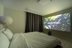 a hotel room with a bed and a projection screen at Haeundae Chocho stay 2 in Busan