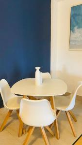 Puerto Santo Tomás de Castilla的住宿－Hotel Gran Costa Azul，白色的桌子,上面有白色的椅子和花瓶