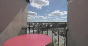 a pink table on a balcony with a view at Sous les toits de Paris shared place in Paris