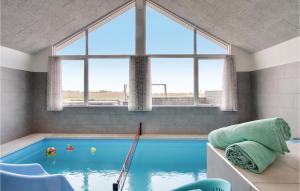 a swimming pool in a room with a large window at Lovely Home In Bogense With House Sea View in Bogense