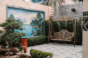 un banco frente a una pared con un mural en Diamond Hotel, en Hai Phong