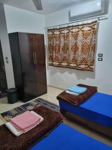 a room with a bed and a curtain and towels at ABAZIDO Nubian Guest House in Aswan