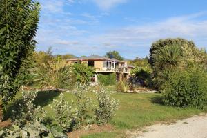 a house in the middle of a yard at Labyrinth Gardens Guest House in Takaka