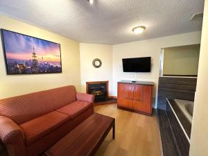 a living room with a couch and a flat screen tv at Riviera Inn And Suites 1000 Islands in Gananoque